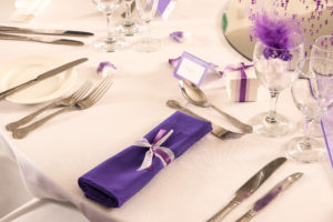 Table dressed with purple themed place settings for a wedding at mercure hotels