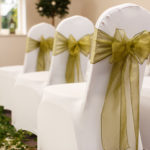 Close up of a dressed chair with a green ribbon prepared for a wedding at mercure hotels