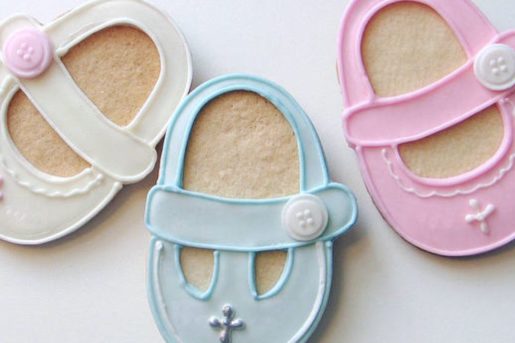 Cookies with baby shoe style icing in cream, blue and pink.